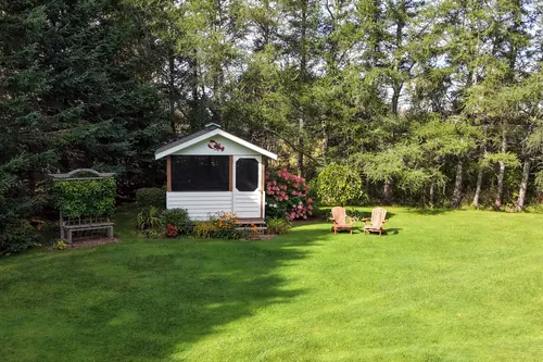 The gazebo and surrounding shrubs at the far end of the back lawn